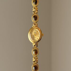 Vintage style gold tone watch with brown gemstone